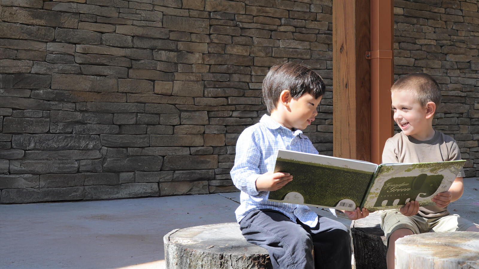 two preschoolers reading a book