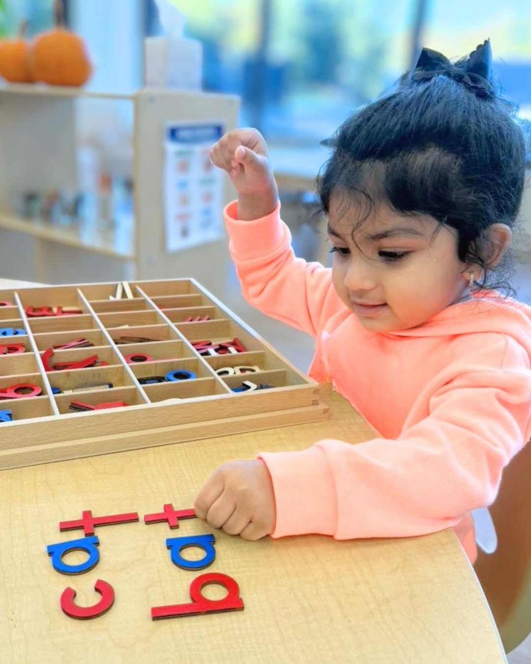 Preschool child building words with movable letters during hands-on learning at Ivybrook Academy Mount Pleasant.