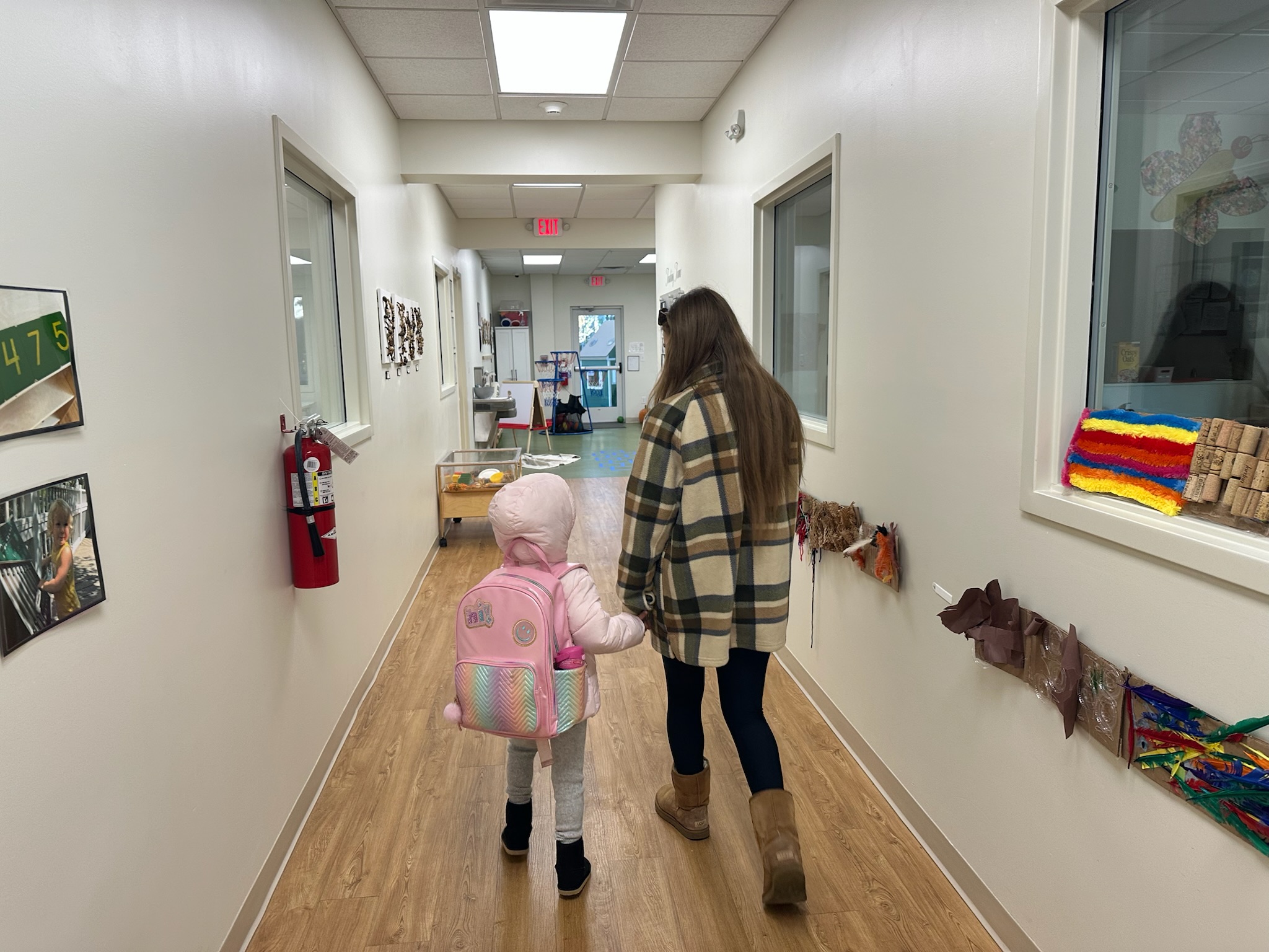 Parent walking a young child down the preschool hallway during morning drop-off at Ivybrook Academy Mount Pleasant.